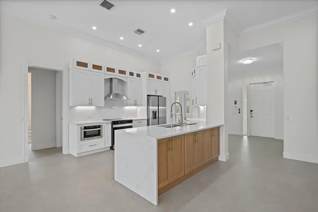 a kitchen with stainless steel appliances kitchen island a sink stove and cabinets