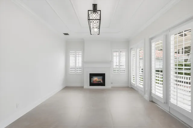 an empty room with windows and fireplace