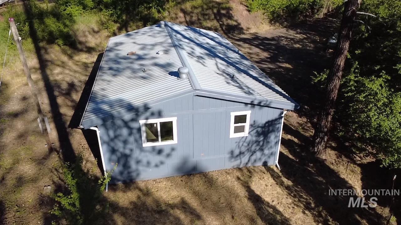 151 View Road Kamiah, ID 83536 - Photo 42 of 49 Compact structure featuring light blue siding with white trim around windows, a corrugated metal roof, and white rain gutters