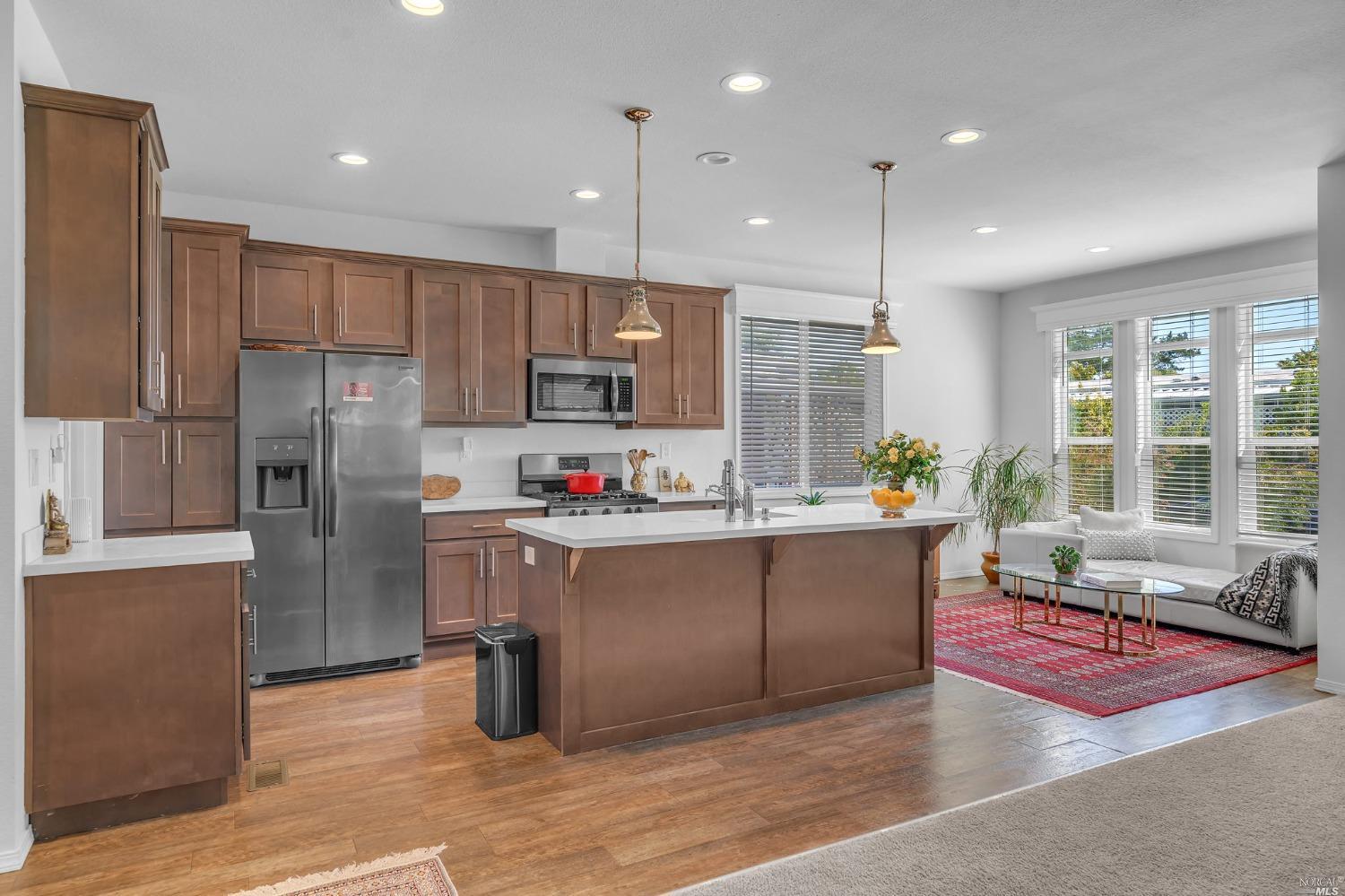 a kitchen with stainless steel appliances granite countertop a refrigerator a oven a sink and a refrigerator