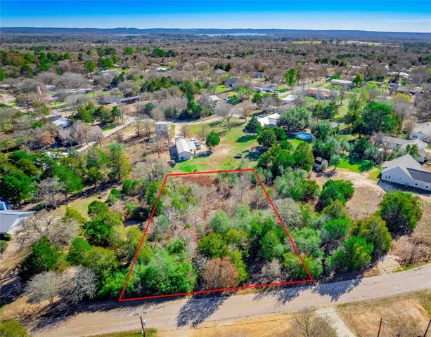 an aerial view of a forest with a yard