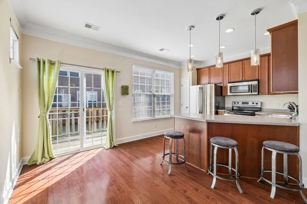 a room with stainless steel appliances wooden floors and view living room