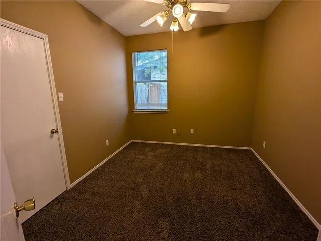 a view of a room with a chandelier fan and a window