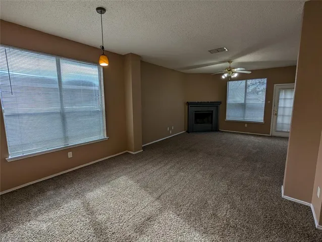 a view of empty room with fireplace and window