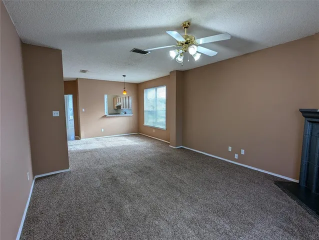 a view of an empty room with a chandelier fan
