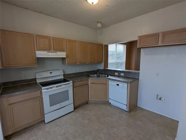 a kitchen with granite countertop a stove sink and cabinets