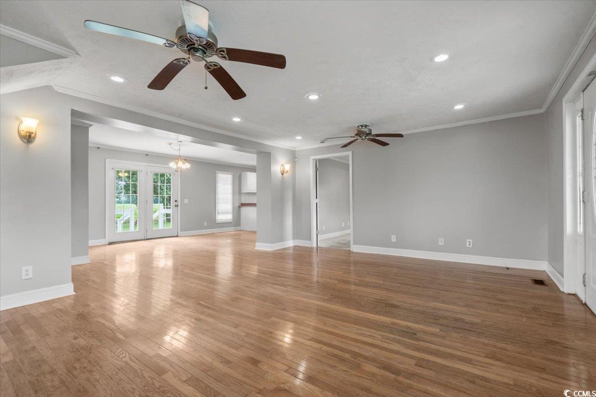 148 High Hill Road Lake View, SC 29563 - Photo 15 of 40 Unfurnished living room featuring crown molding, hardwood / wood-style flooring, recessed lighting, a ceiling fan, and french doors