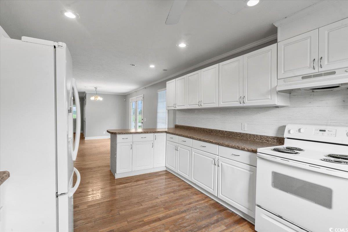148 High Hill Road Lake View, SC 29563 - Photo 25 of 40 Kitchen featuring white appliances, white cabinets, light wood-style flooring, dark countertops, and recessed lighting