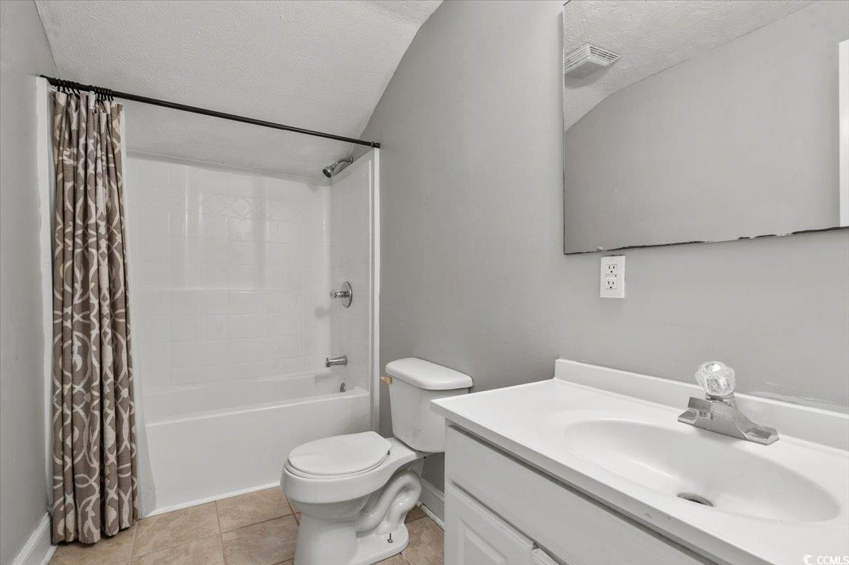 148 High Hill Road Lake View, SC 29563 - Photo 34 of 40 Full bathroom featuring a textured ceiling, light tile patterned floors, shower / bath combo with shower curtain, and vanity