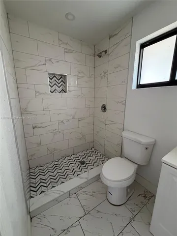 a bathroom with a toilet and a shower