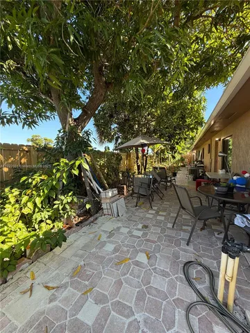 a view of a patio with table and chairs and potted plants