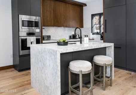 a kitchen with a table chairs sink and cabinets