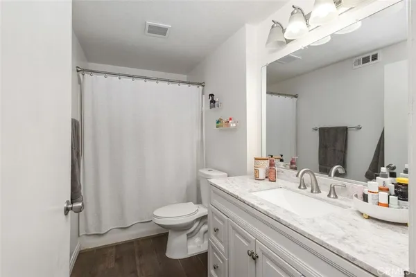 a bathroom with a granite countertop sink toilet and shower