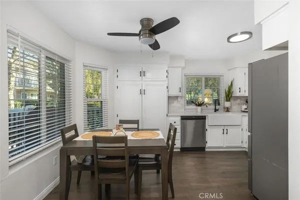 a kitchen with a table chairs a sink dishwasher window and cabinets