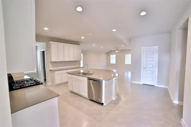 a kitchen with kitchen island a sink stainless steel appliances and cabinets