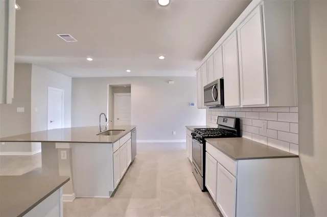 a kitchen that has a sink and a stove in it