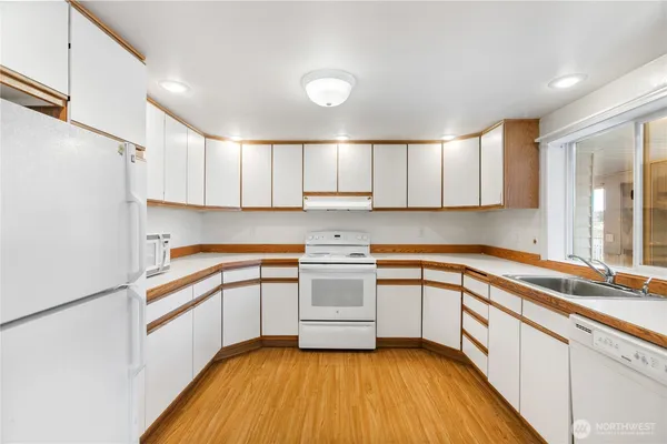 a kitchen with a sink cabinets stainless steel appliances and a window