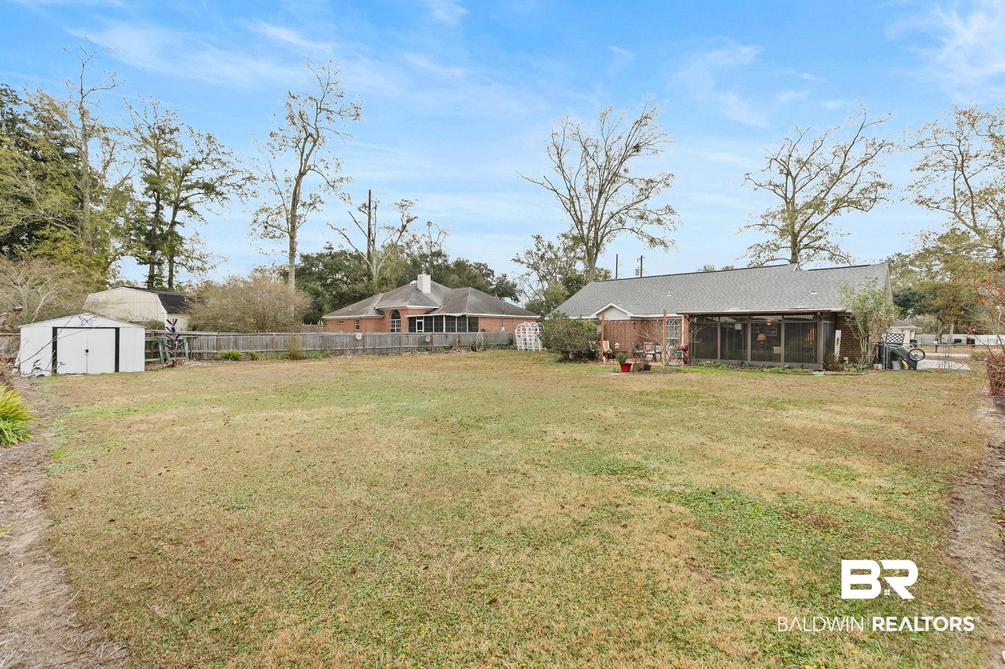 519 Juniper Place Drive Foley, AL 36535 - Photo 35 of 47 Fenced backyard featuring a storage shed and a sunroom