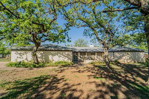 front view of a house with a large tree
