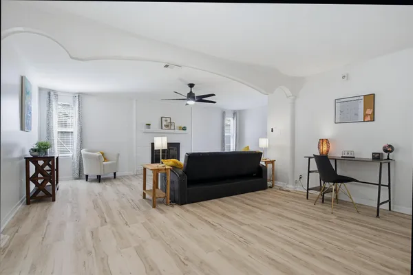 a living room with furniture and a wooden floor