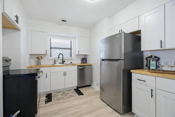 a kitchen with a refrigerator sink and cabinets