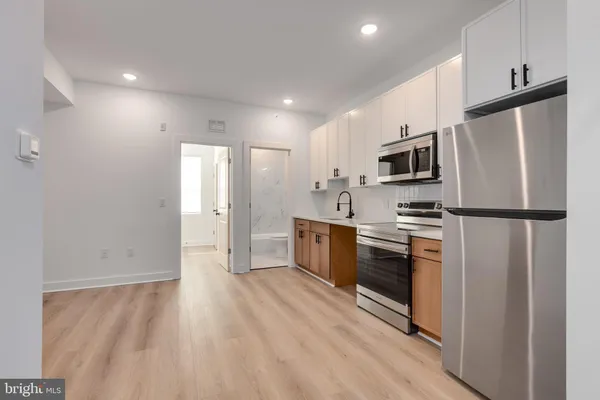 a kitchen with stainless steel appliances a refrigerator sink and microwave