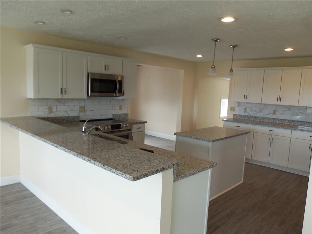 636 Wilson Mill Road New Castle, PA 16105 - Photo 8 of 18 a kitchen with kitchen island granite countertop a sink a stove a microwave a counter top and cabinets