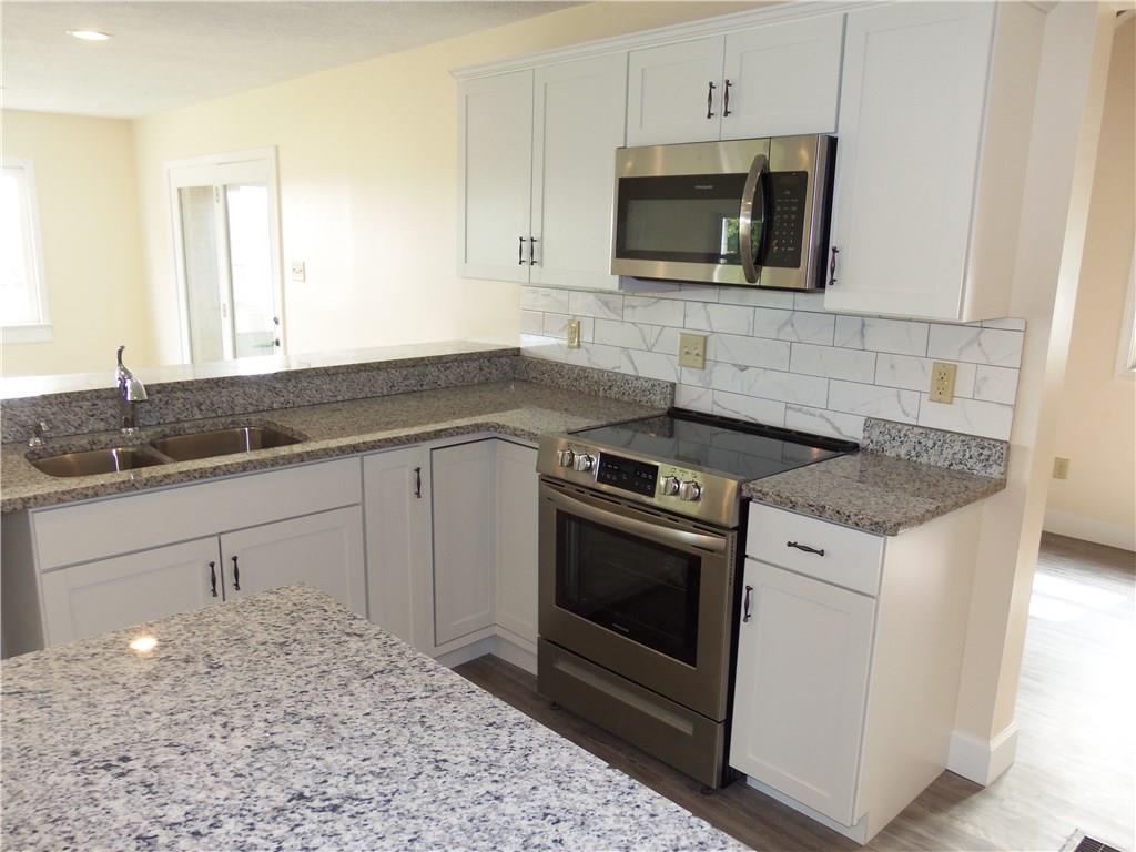 636 Wilson Mill Road New Castle, PA 16105 - Photo 9 of 18 a kitchen with granite countertop a stove sink and microwave