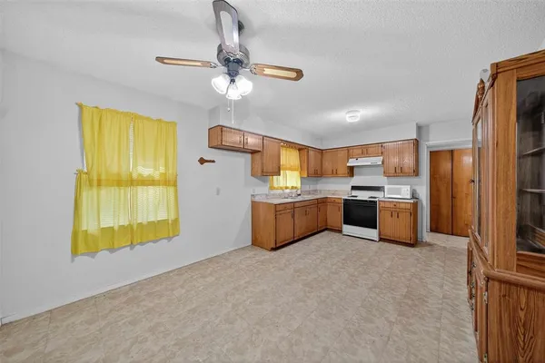 a large kitchen with a window and stainless steel appliances