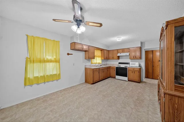 a large kitchen with a window and stainless steel appliances
