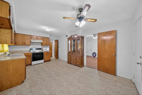 a kitchen with stainless steel appliances kitchen island granite countertop a refrigerator and a sink