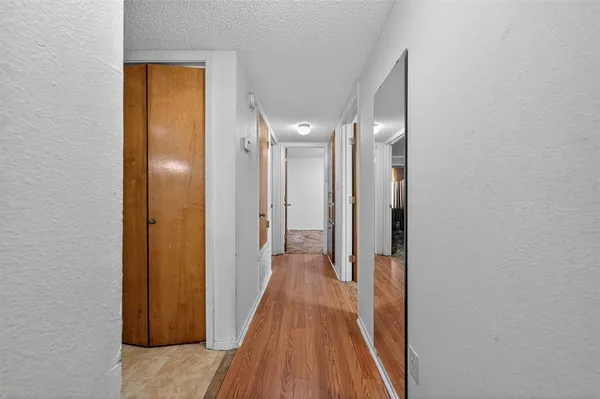 a view of a hallway with wooden floor