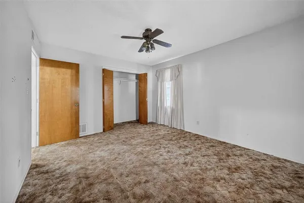 a view of a livingroom with a ceiling fan and window