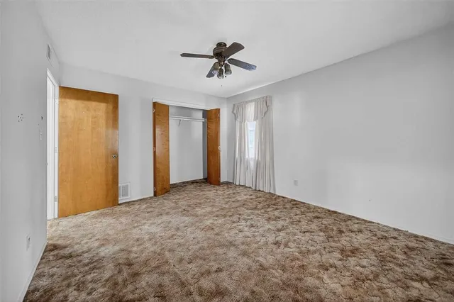 a view of a livingroom with a ceiling fan and window