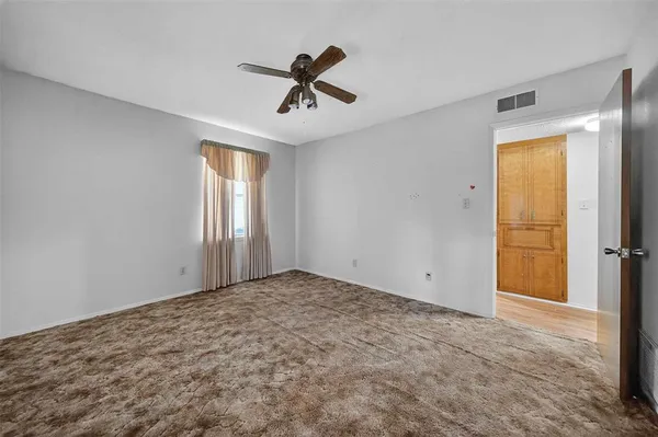 a view of empty room with ceiling fan