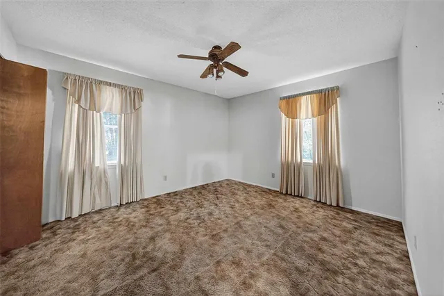 a view of a livingroom with a ceiling fan and window