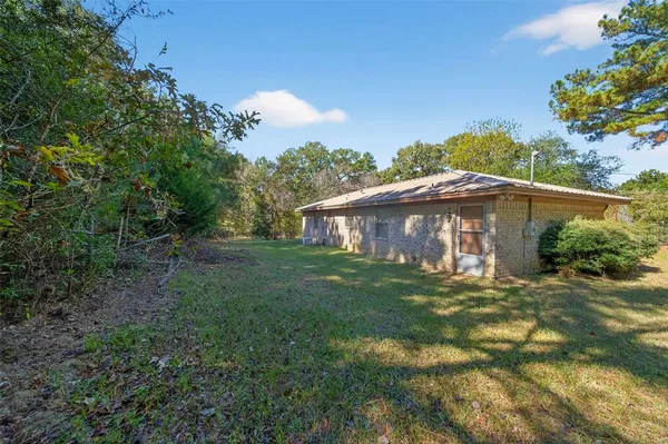 a view of a yard in front of a house with large trees