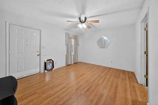 a view of a room with wooden floor and ceiling fan