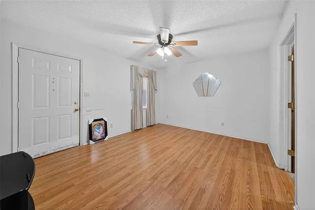 a view of a room with wooden floor and ceiling fan