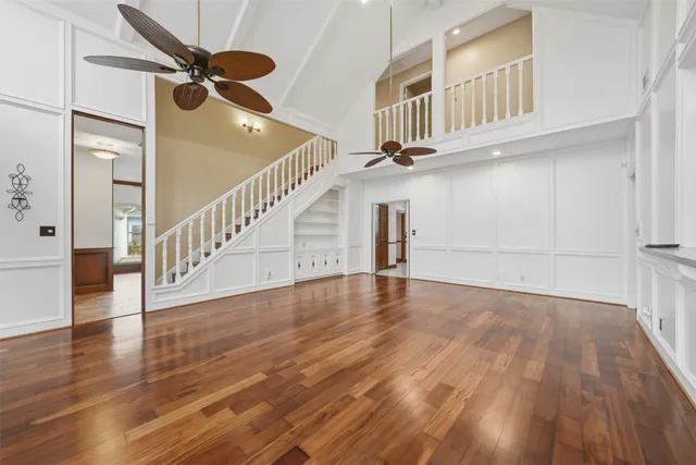 a view of an empty room with a window and wooden floor