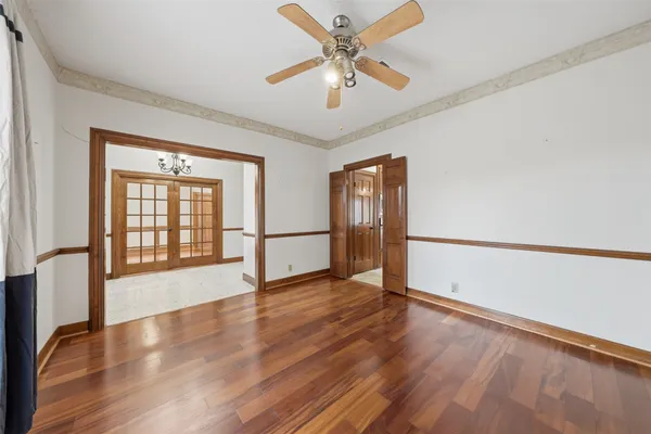 a view of an empty room with window and wooden floor