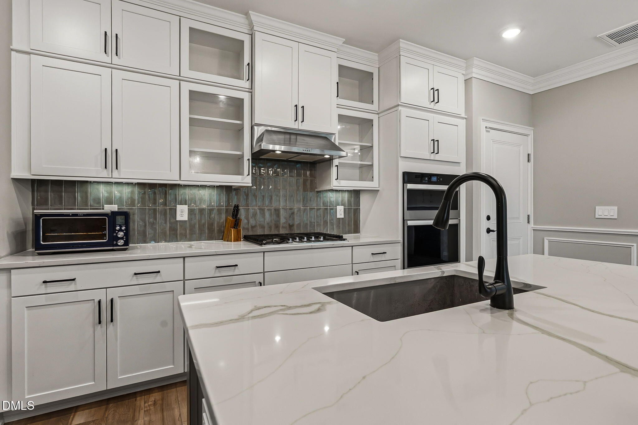438 Diversity Way Raleigh, NC 27610 - Photo 13 of 33 a kitchen with white cabinets and black appliances