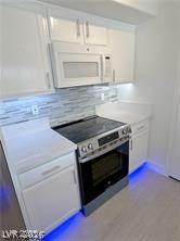 7255 West Sunset Road, Unit 2046 Las Vegas, NV 89113 - Photo 5 of 28 A contemporary kitchen offers sleek white cabinetry and bright under-cabinet lighting.
