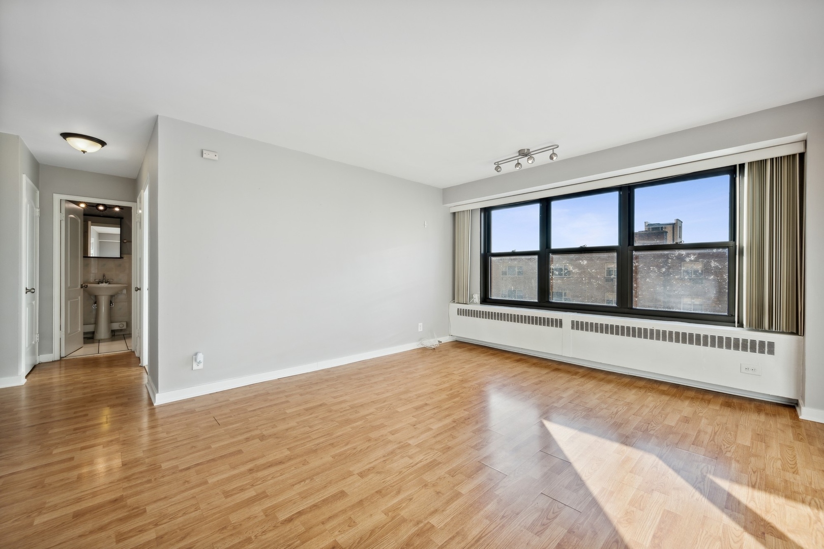 6118 North Sheridan Road, Unit 509 Chicago, IL 60660 - Photo 2 of 10 wooden floor in an empty room with a window