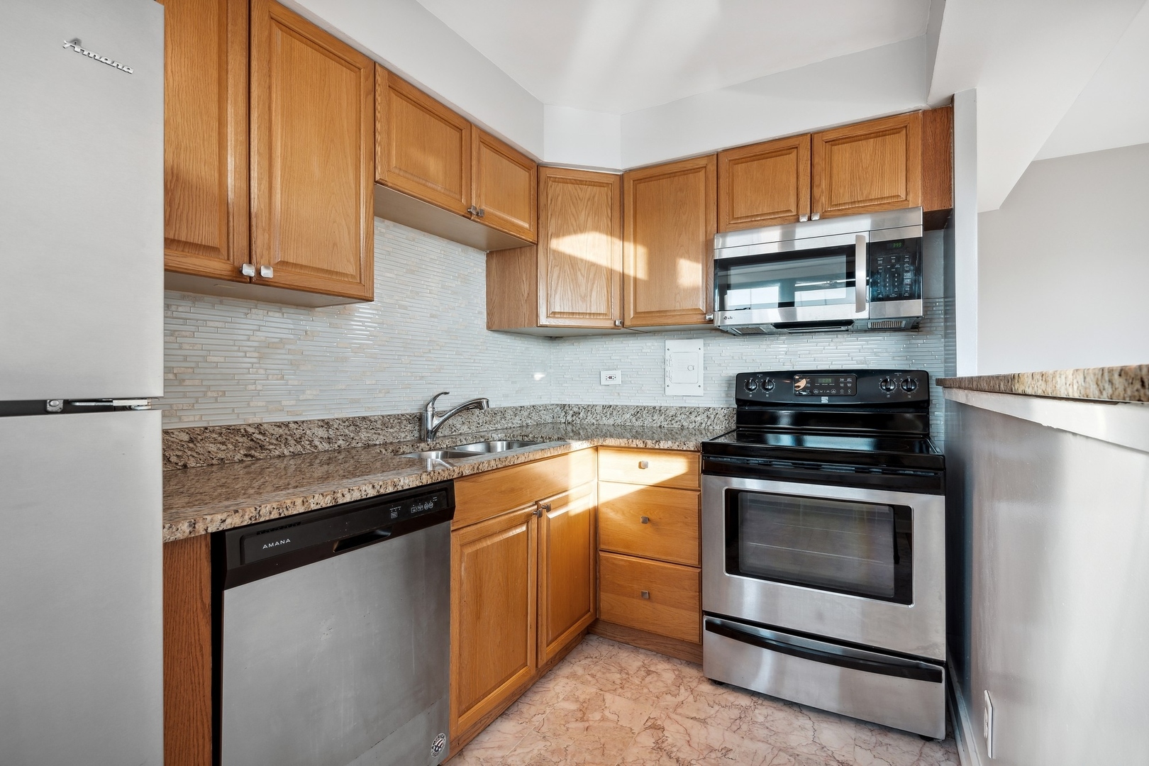 6118 North Sheridan Road, Unit 509 Chicago, IL 60660 - Photo 3 of 10 a kitchen with stainless steel appliances granite countertop a stove and a microwave