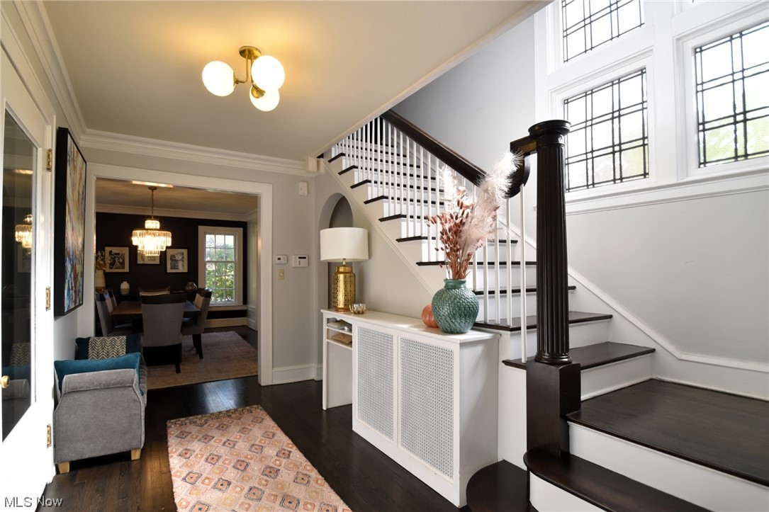 2257 South Overlook Road Cleveland, OH 44106 - Photo 3 of 35 Stairs with an inviting chandelier, dark wood-type flooring, and crown molding
