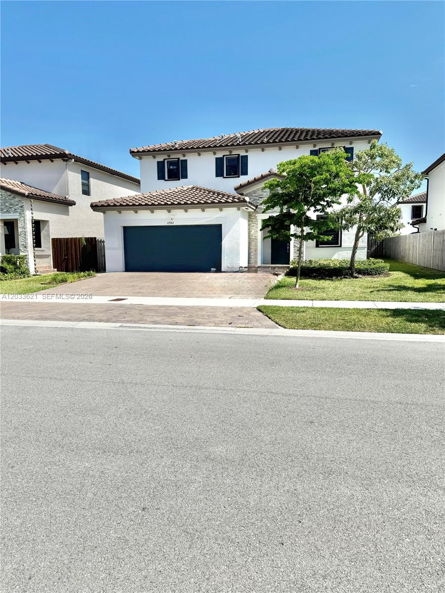 11942 Southwest 243rd Street Homestead, FL 33032 - Photo 1 of 50 a front view of a house with a yard