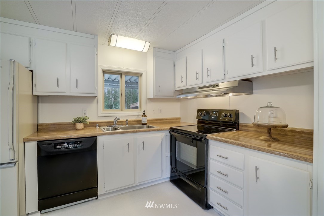 319 West Shore Loop Road Snohomish, WA 98290 - Photo 21 of 32 a kitchen with stainless steel appliances granite countertop a sink stove and cabinets
