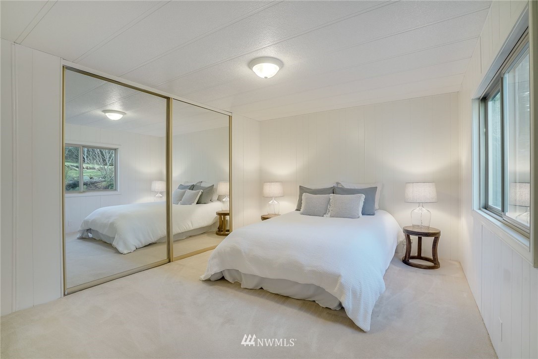 319 West Shore Loop Road Snohomish, WA 98290 - Photo 22 of 32 a bedroom with a large bed and a chandelier