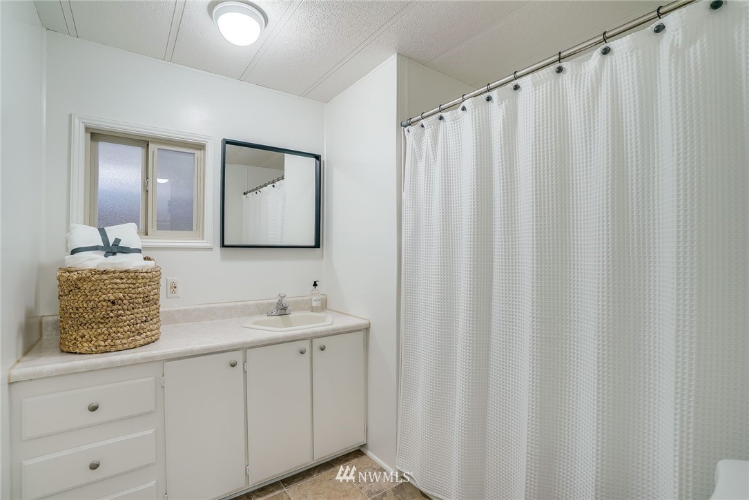 319 West Shore Loop Road Snohomish, WA 98290 - Photo 23 of 32 a bathroom with a shower curtain and a mirror